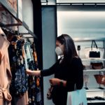 Customer experience changes during pandemic for consumers, like this woman shopping retail while wearing a mask.