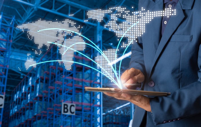 Returning to Home Soil: Reshoring Can Help Alleviate Supply Chain Issues, but It Needs Tech to Keep the Costs Down Businessman manager using tablet check and control for workers with Modern Trade warehouse logistics.