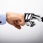Human and robot hand making a fist bump.