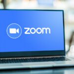 Laptop computer displaying logo of Zoom.