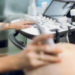 Doctor performs ultrasound on pregnant woman