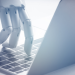 Robot finger point to laptop button.