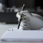Robot hand writing on a notebook.