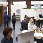 Business teams working at desks in modern open plan office.
