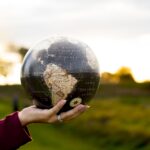 A closeup shot of a female holding a globe with a blurred background