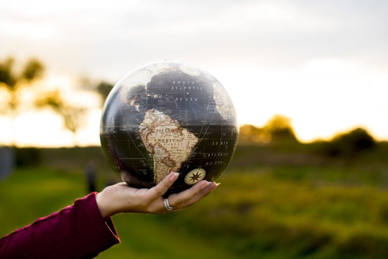 A closeup shot of a female holding a globe with a blurred background