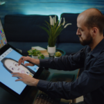 Media artist working on an image using a touch screen monitor.