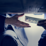 Two persons exchanging money under the table.
