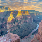 Sunset view of the Grand Canyon with person on edge.