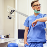Dentist in a room with medical equipment on the background.