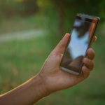 Hand holding a black smartphone.