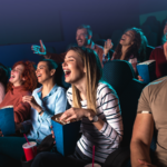 Group of people laughing while watching a movie.