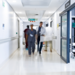 Blurred motion of doctors and medical staff walking on a hospital hallway.