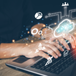 Businesswoman using laptop to access cloud computing system with various cloud-related images on virtual screen.