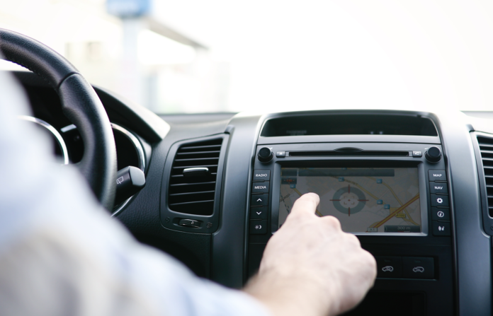 Man interacting with the dashboard infotainment screen inside a car.