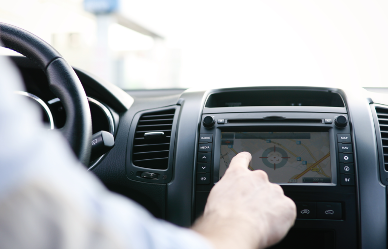 Man interacting with the dashboard infotainment screen inside a car.