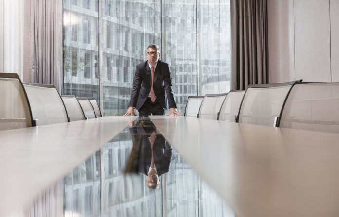 An executive standing on a conference table.