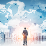Businessman looking towards an abstract background of the world map and city scape.
