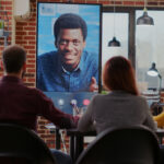 Group of workmates attending video call meeting with man