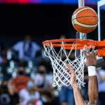 Basketball going through a hoop in a basketball game.