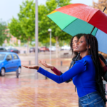 Friends checking rain under an umbrella.