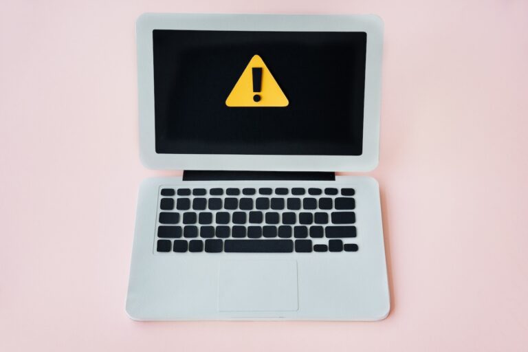 Stock photo of a laptop with a warning indicator on the screen.