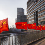 Row of Chinese flags on Huangpu river promenade, Shanghai, China.