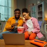 Stock photo of two young adults watching a movie.