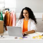 A woman shopping clothes online using her laptop.