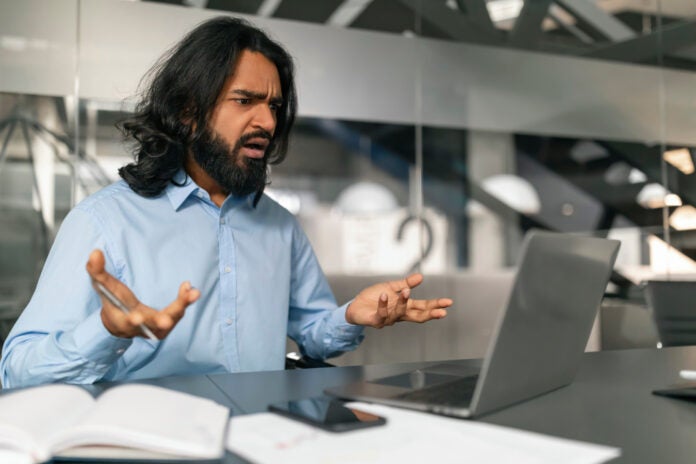 frustrated-man-with-laptop-2025-03-18-17-16-39-utc (1) An employee getting frustrated in front of his laptop.