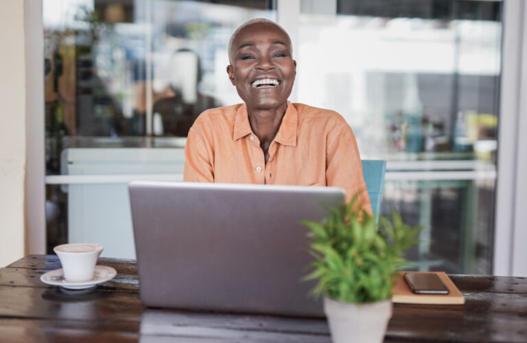 Woman sitting in a bar outdoor and working with laptop.