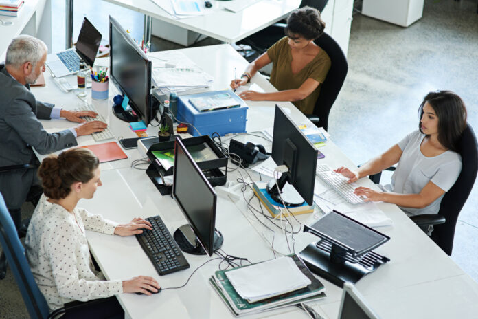 Four employees working hard inside the office.
