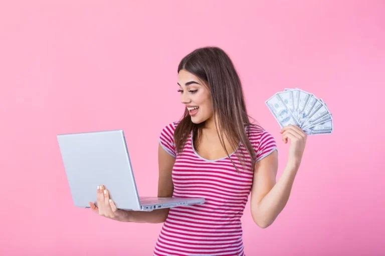 girl holding laptop & money