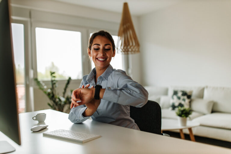 A woman checking on her smartwatch for time.