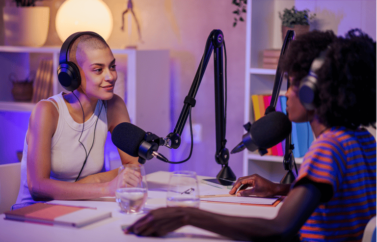A podcast guest is sitting in a home recording studio with her friend