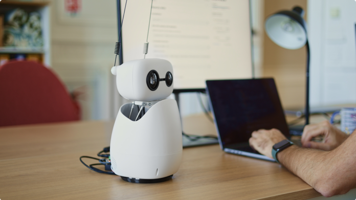 Photo of a Hugging Face Reachy Mini robot on a desk.